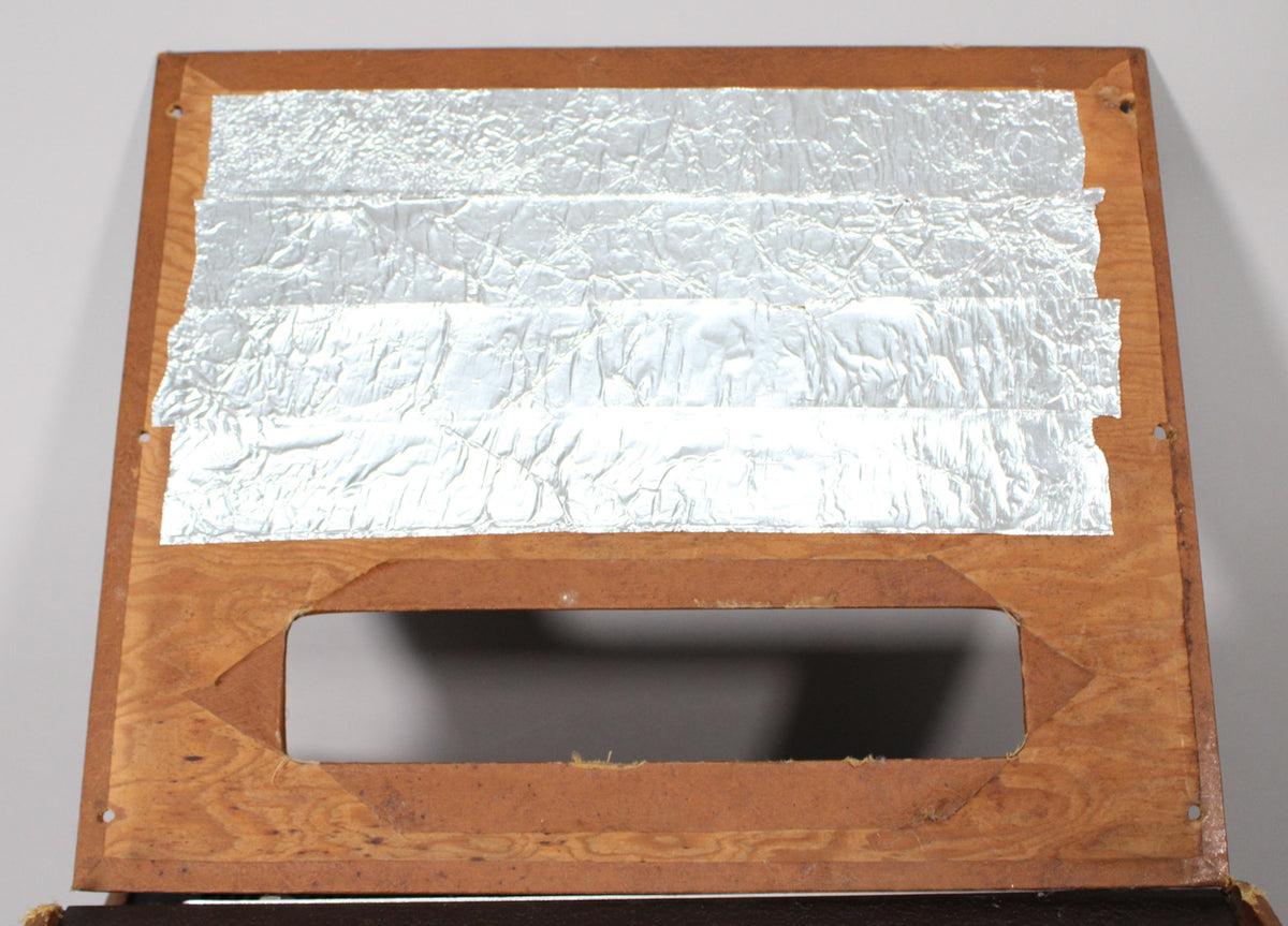 Top-down view of the amp's wooden back panel, with five strips of crinkled aluminum foil and a rectangular cutout.