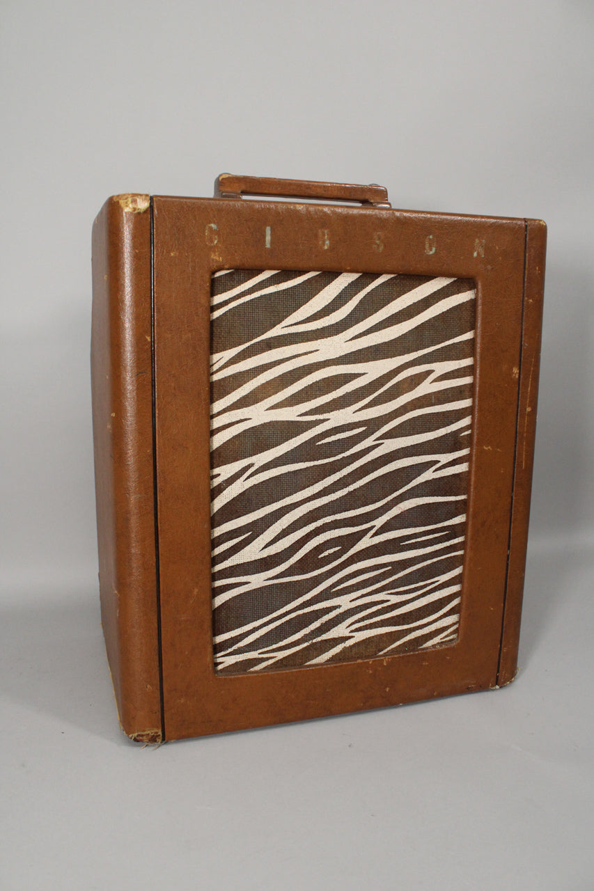 Brown leatherette amp, angled to show the front and left side, with a zebra-print grille and visible wear on the top left corner.