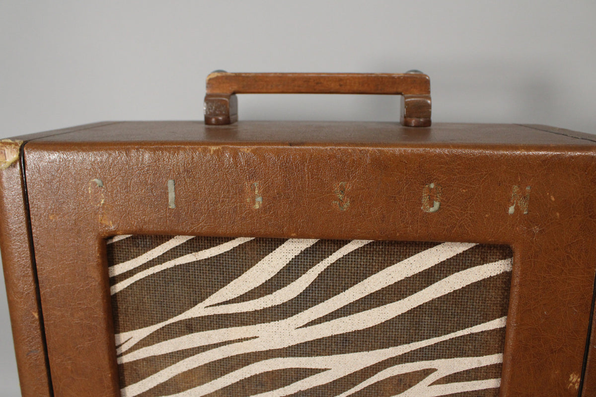 Top-down view of the brown leatherette amp, showing the wooden handle and zebra-stripe grille cloth with visible wear and corner damage.
