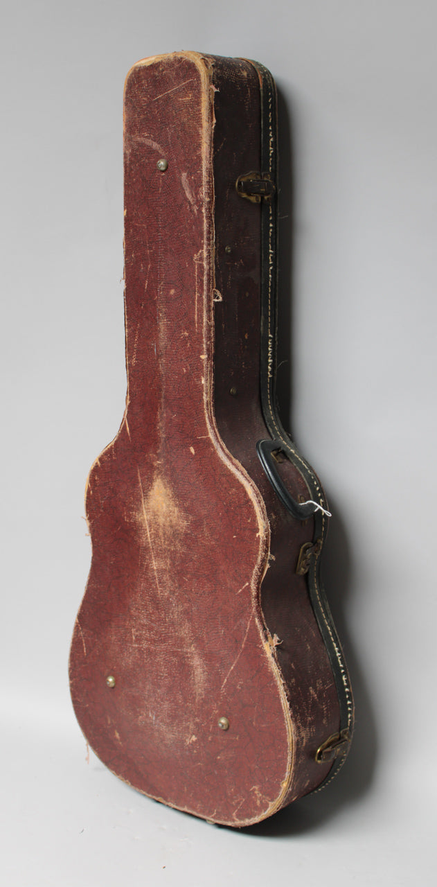 The brown snakeskin case is angled right, showing its worn, scuffed top with a black handle and a single brass latch.