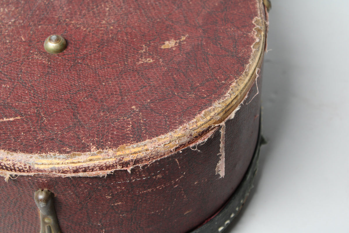 Close-up of the case's rounded corner, showing significant wear, peeling brown snakeskin, and exposed wood along the edge.