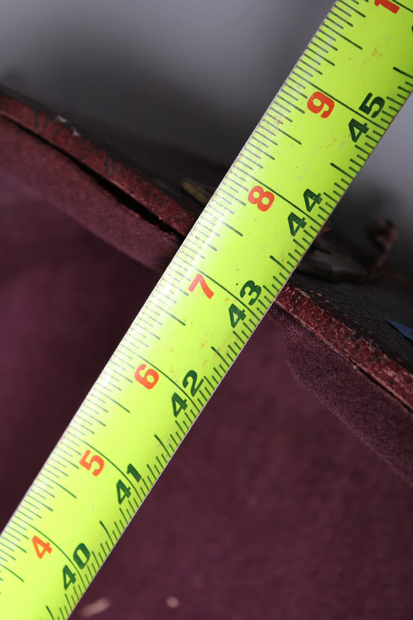 A bright yellow tape measure shows the case's length from 40 to 45 inches, with visible wear and separation along the brown snakeskin edge.