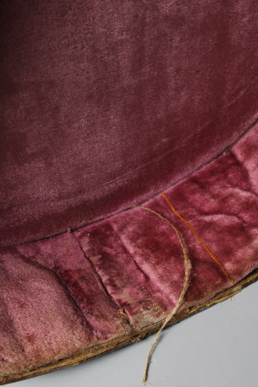 Close-up of the case's pink velvet interior, showing wear, discoloration, and loose threads along the bottom edge.