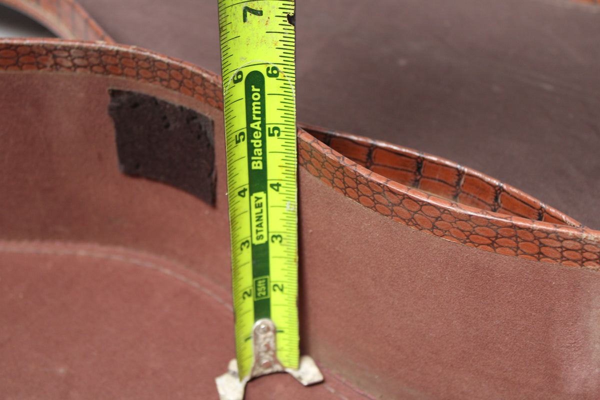 A close-up of the brown alligator-patterned case interior, with a yellow tape measure showing a depth of 6 inches.