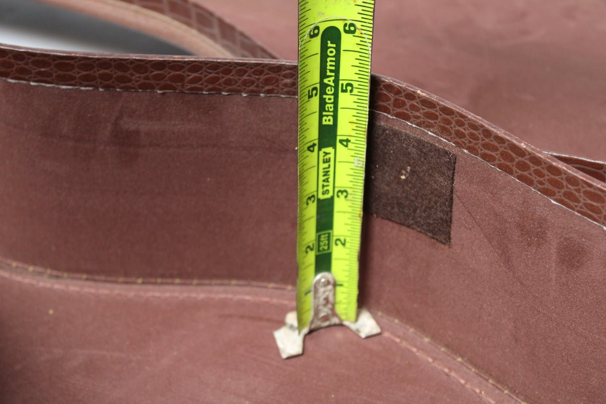 Close-up of the brown alligator-patterned case lining, with a yellow tape measure showing 0-6 inches.