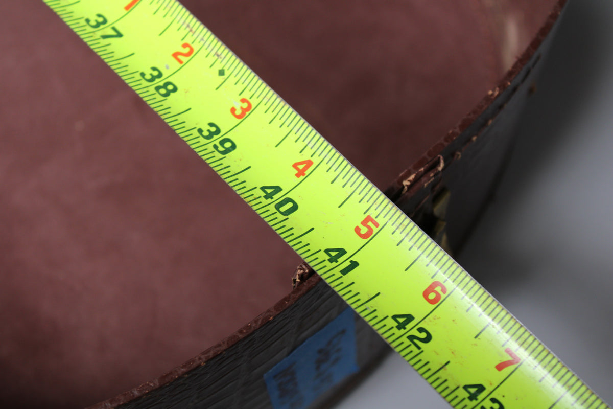 A bright yellow tape measure extends diagonally across the brown case, showing measurements from 37 to 43 inches.