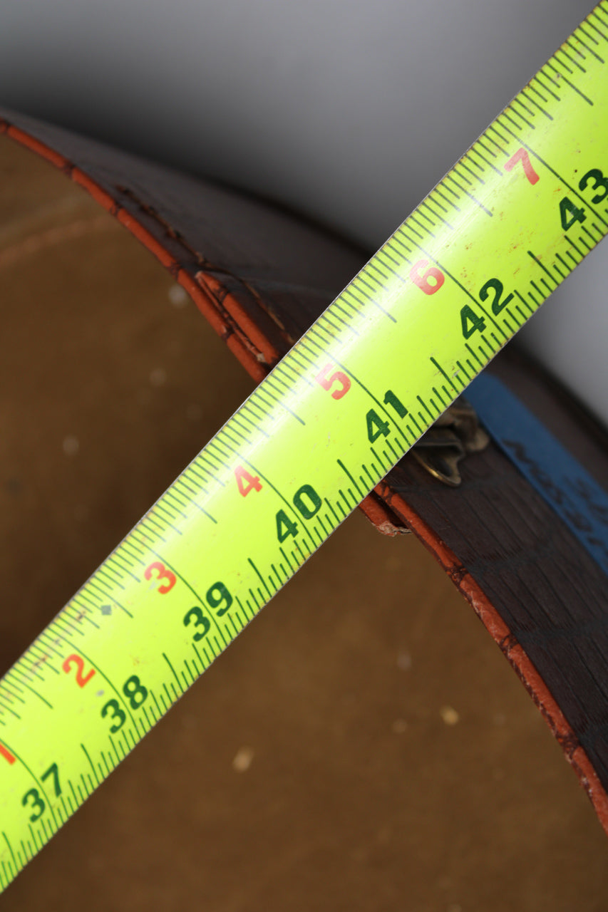 A bright yellow tape measure diagonally crosses the brown snakeskin case, showing measurements from 37 to 43 inches.