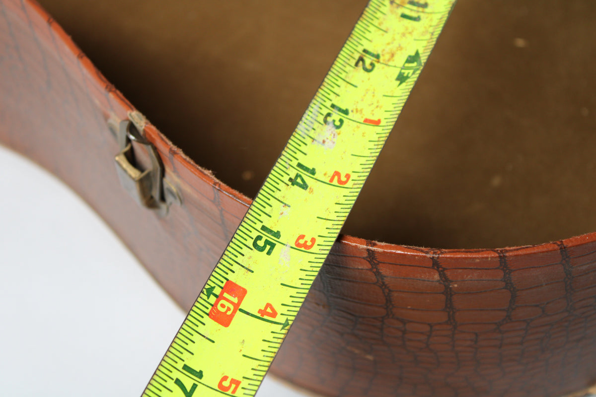 A close-up of the brown snakeskin-patterned case shows a brass latch and a yellow measuring tape indicating 11 to 17 inches.