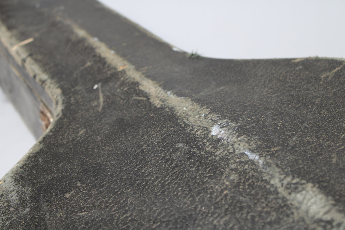 Close-up of the black textured case exterior, showing heavy wear and scuffs along the center seam and edges.