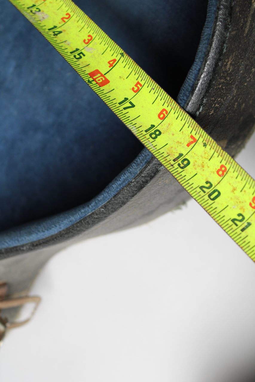 A yellow tape measure spans the case's blue plush lining and worn black exterior, showing a measurement of 13 to 21 inches.