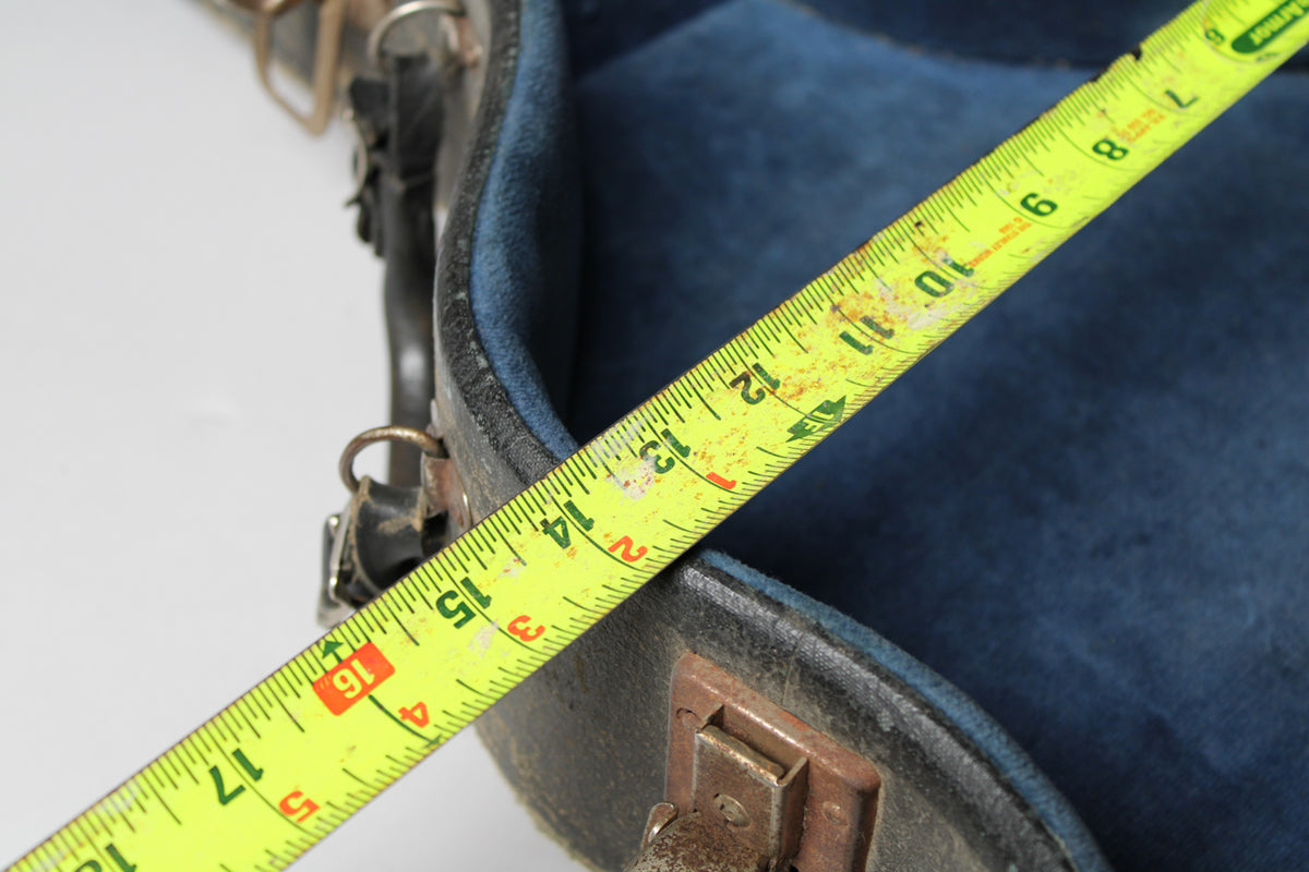 A yellow measuring tape extends diagonally across the open, dark blue velvet-lined case, showing measurements up to 18 inches.