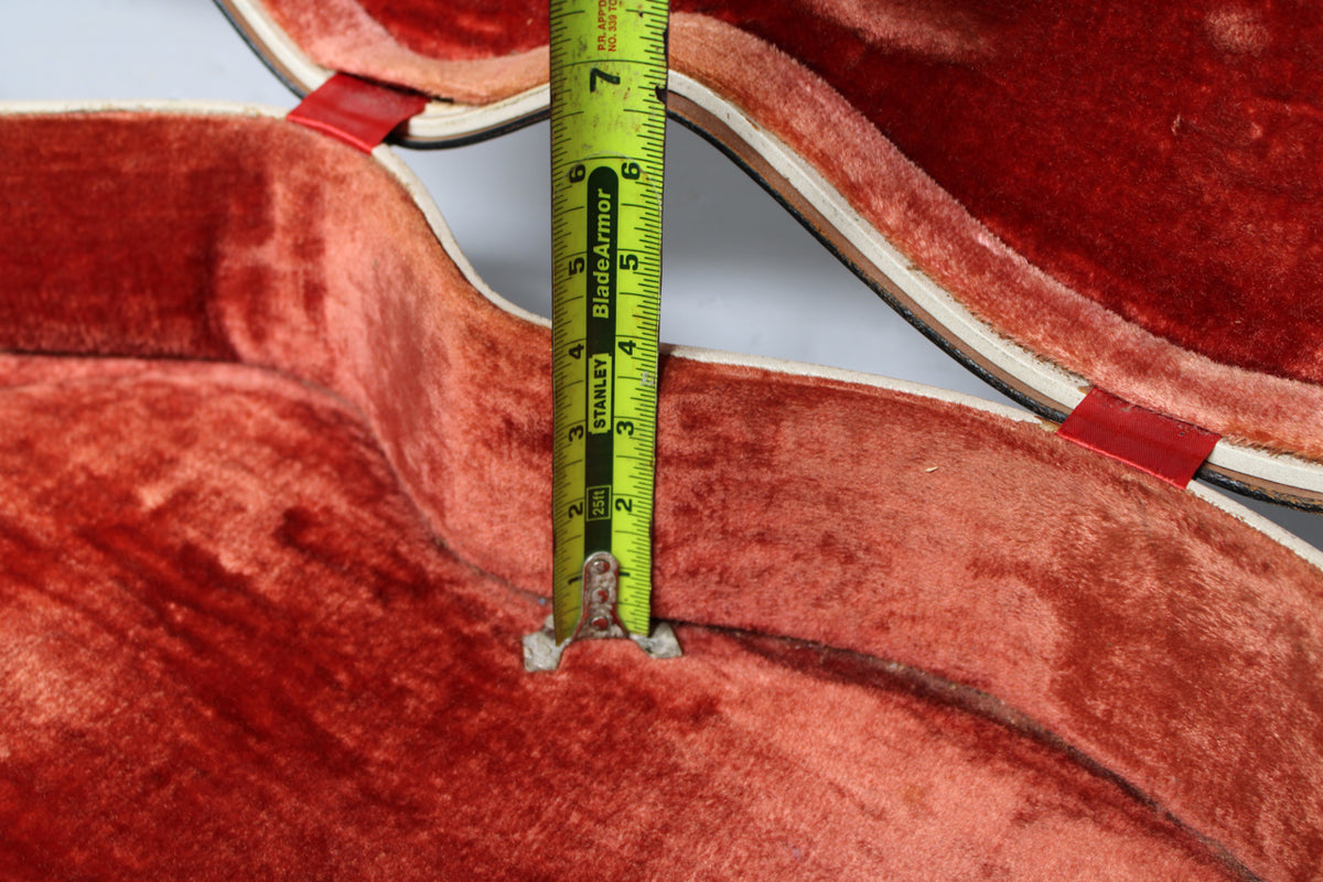 An overhead close-up shows the case's worn, reddish-orange plush interior, with a measuring tape indicating a depth of about 2.5 inches.