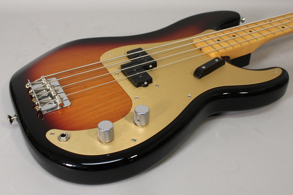Sunburst P-style bass body, angled from the lower bout, showing the gold anodized pickguard, chrome bridge, and knurled knobs.