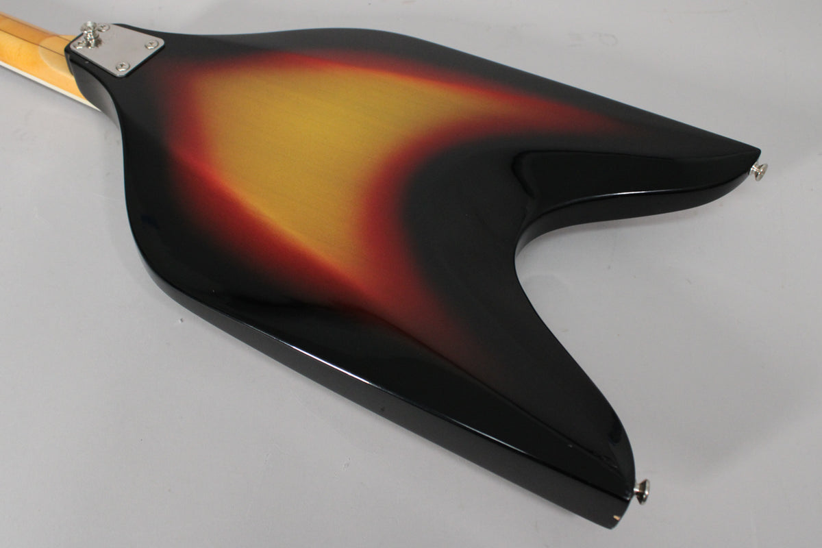 The back of the V-shaped bass body, showing a sunburst finish with black edges, red-orange, and yellow center, with a neck plate.