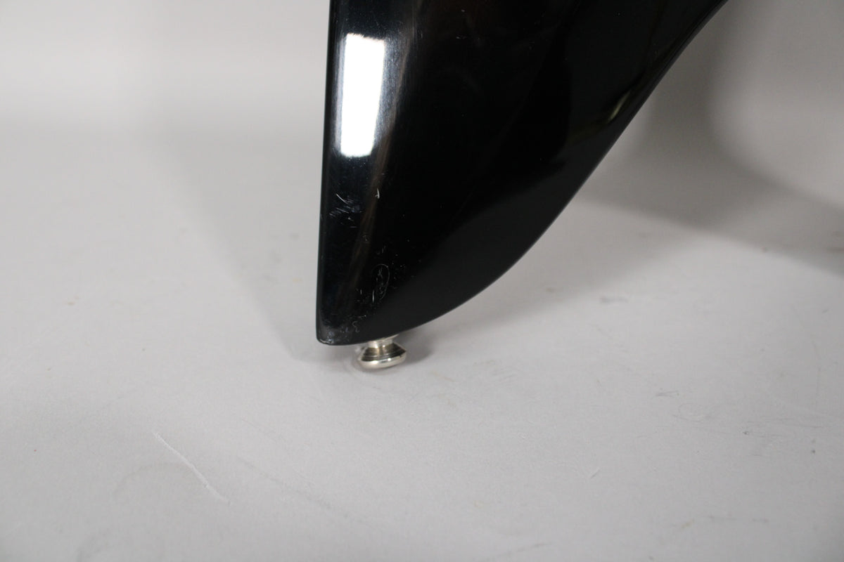 Close-up of the bass's lower horn, showing a chrome strap button and light scratches on the glossy black finish.