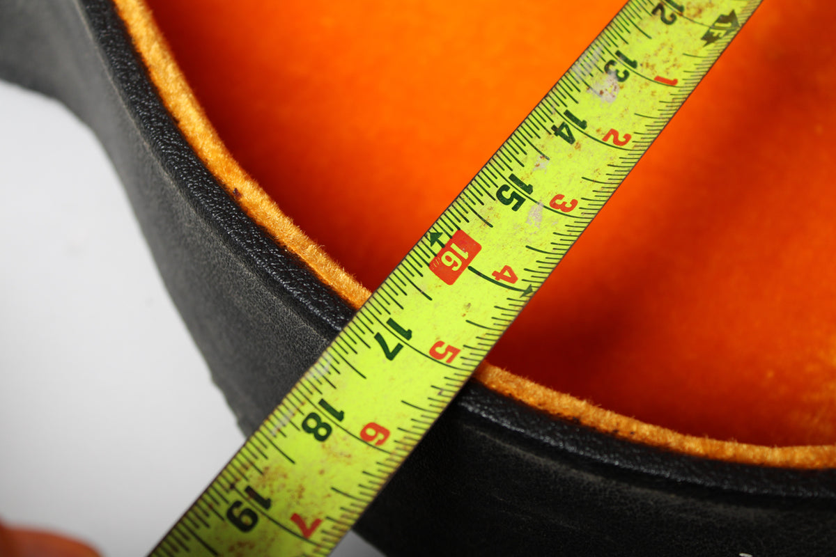 A yellow tape measure shows the black case's orange plush lining is 16 inches across, with some wear visible on the lining.