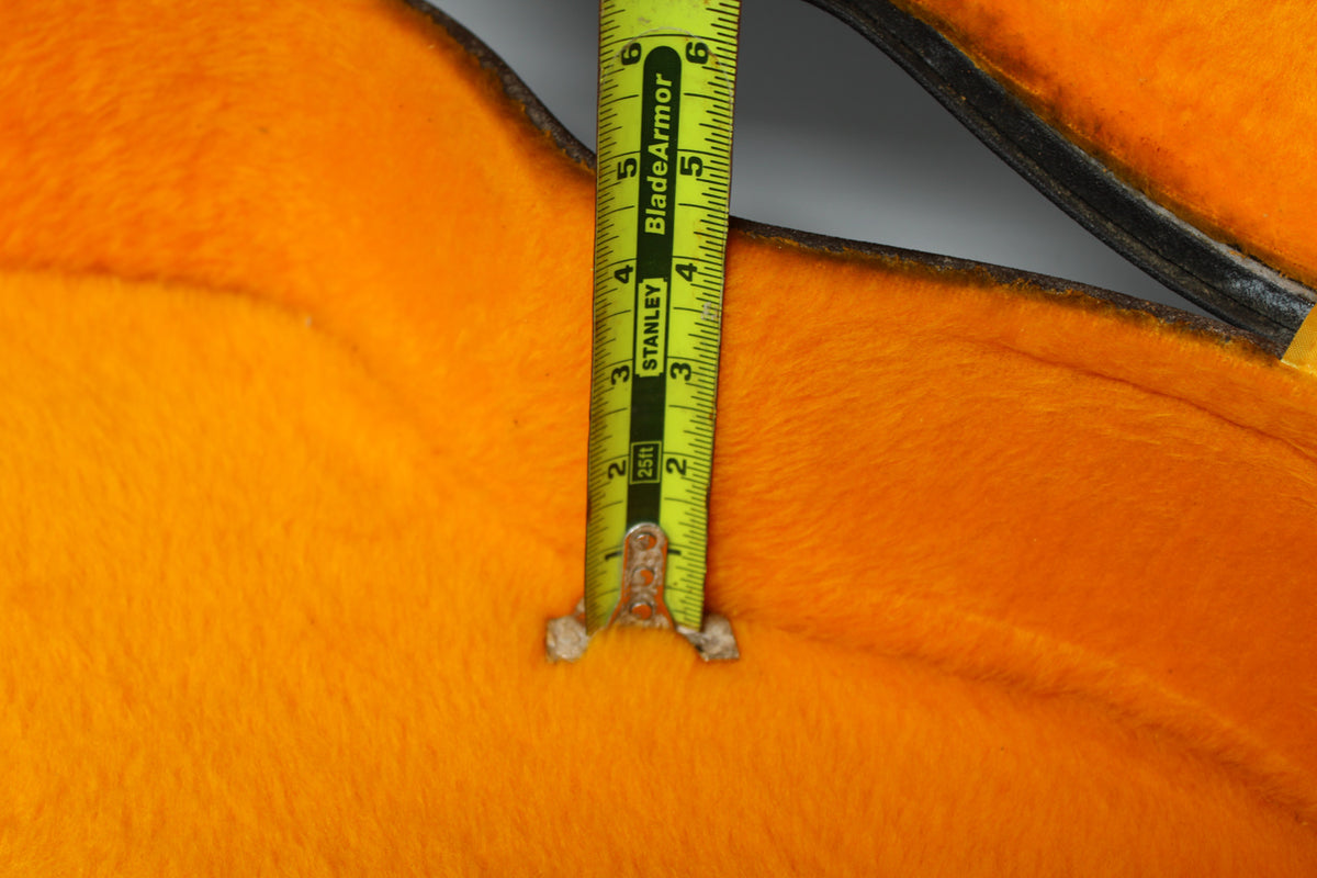 Close-up of the case's bright orange plush interior, with a yellow tape measure showing a depth of approximately 5.5 inches.