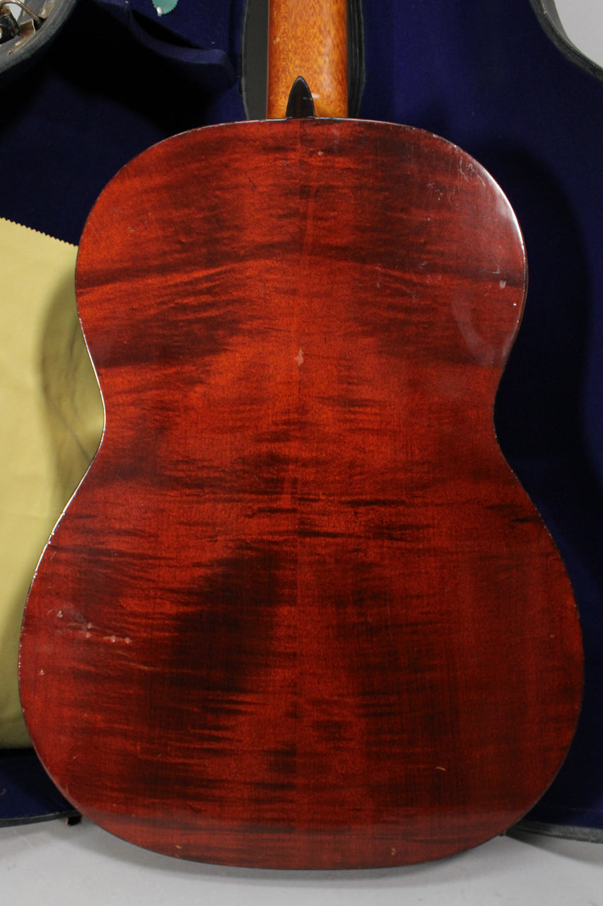 The guitar's dark red back shows prominent wood grain, with light scratches and dings visible on the lower bout and edges.
