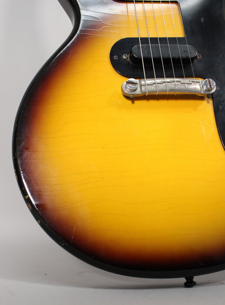 Close-up of the sunburst body with heavy finish checking, showing the single pickup, tune-o-matic bridge, and black pickguard.