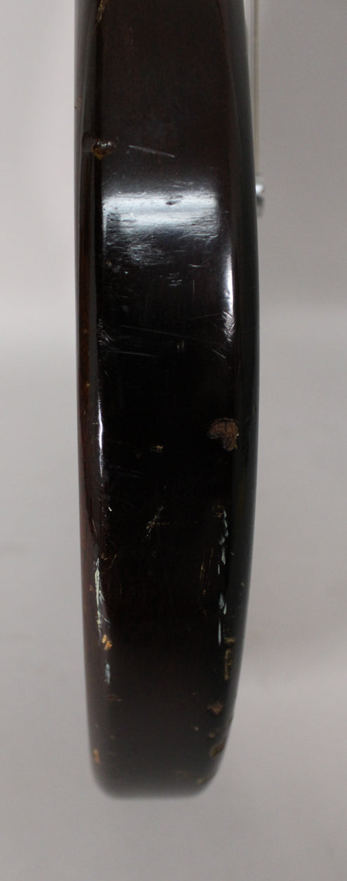 Close-up of the guitar's dark sunburst body edge, showing heavy finish wear, scratches, and chips revealing lighter wood beneath.