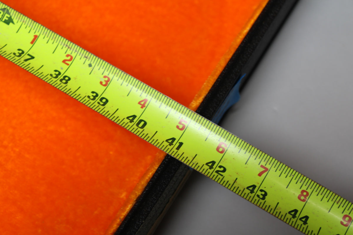 A yellow tape measure diagonally crosses the orange plush interior of the case, showing measurements from 37 to 44 inches.