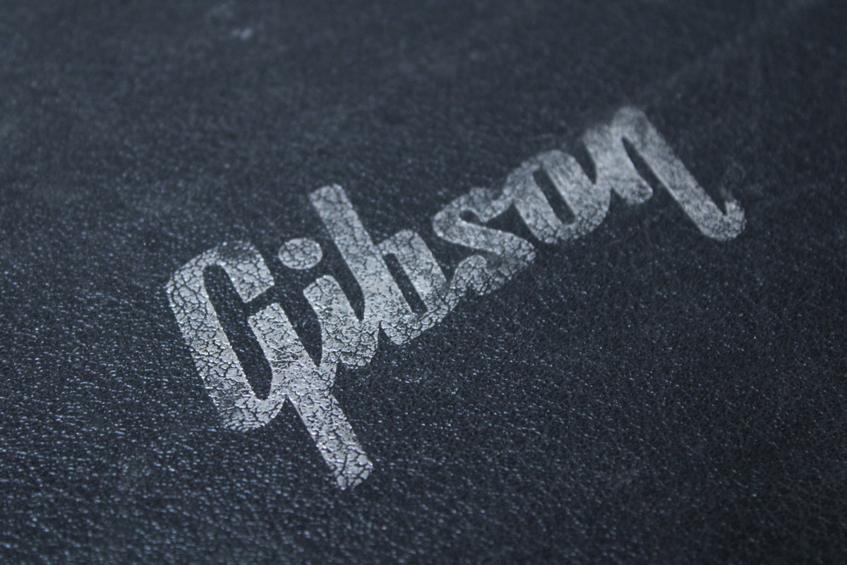 Close-up of the case's black textured exterior, with a faded, cracked white logo diagonally across the center.