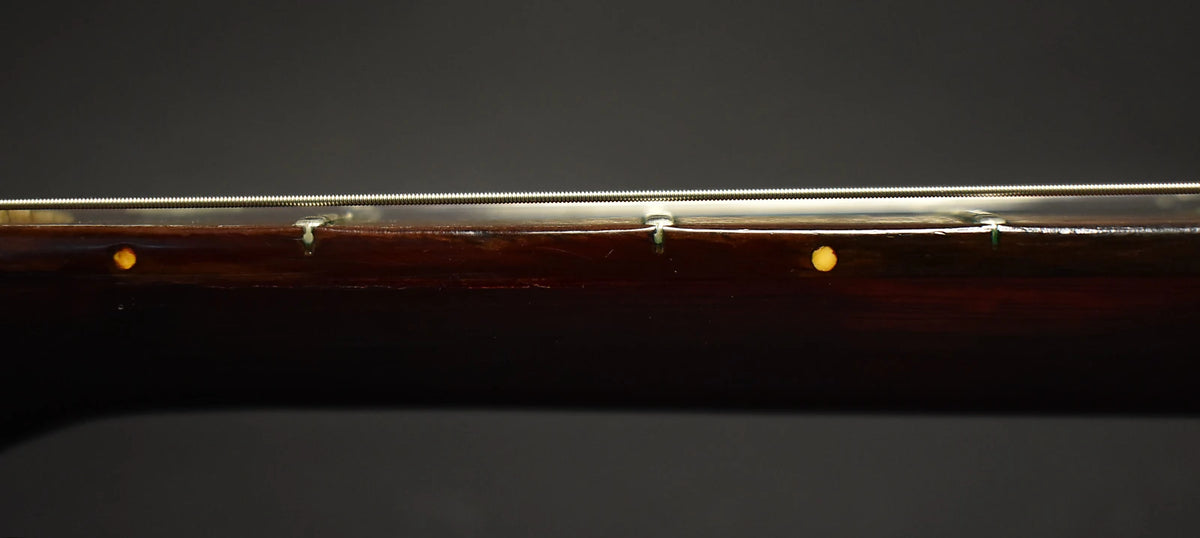 Close-up of the dark cherry red neck, showing the side dots and some finish wear along the top edge.