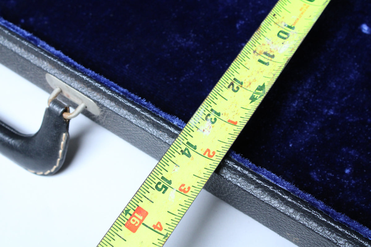 Close-up of the black case's blue velvet interior, with a yellow measuring tape showing 10 to 16 inches.