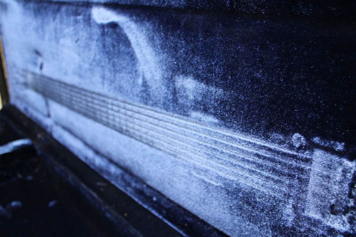 Close-up of the case's dark blue velvet interior, showing wear and indentations from a guitar neck and headstock.