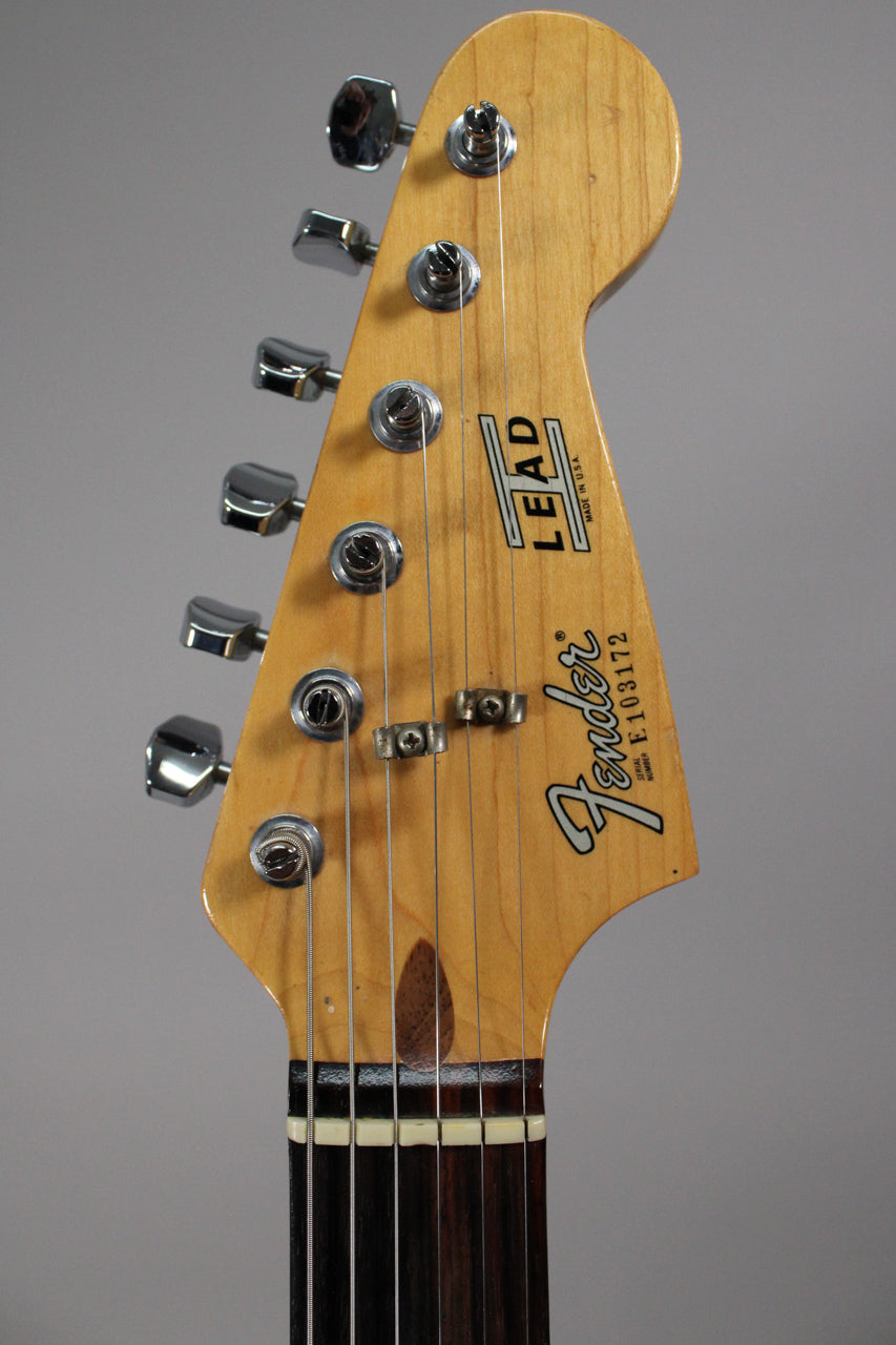 Close-up of the light wood headstock with six chrome tuners, two string trees, and a dark rosewood fretboard.
