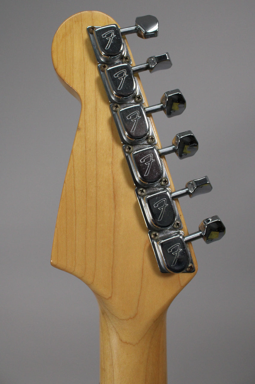 Close-up of the light wood headstock and neck, showing six chrome tuners with some tarnishing and light wear.