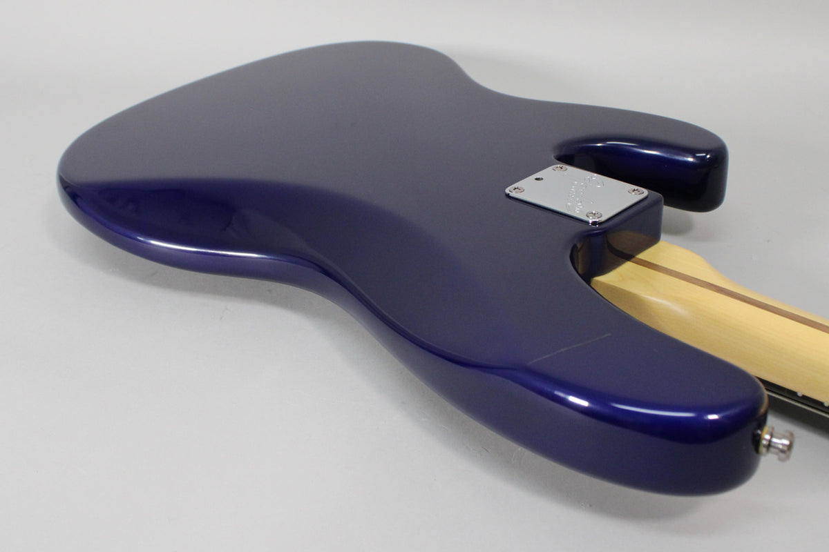 The midnight blue bass body, viewed from the back, shows a chrome neck plate and a light maple neck with a dark stripe.