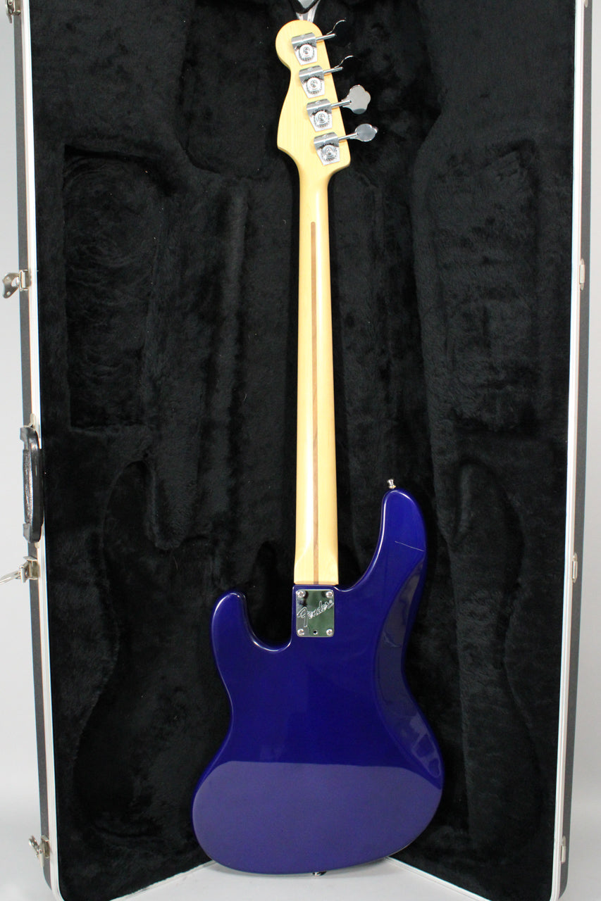 The midnight blue bass is shown from the back, neck-to-body, with a maple neck, chrome tuners, and a shiny finish.
