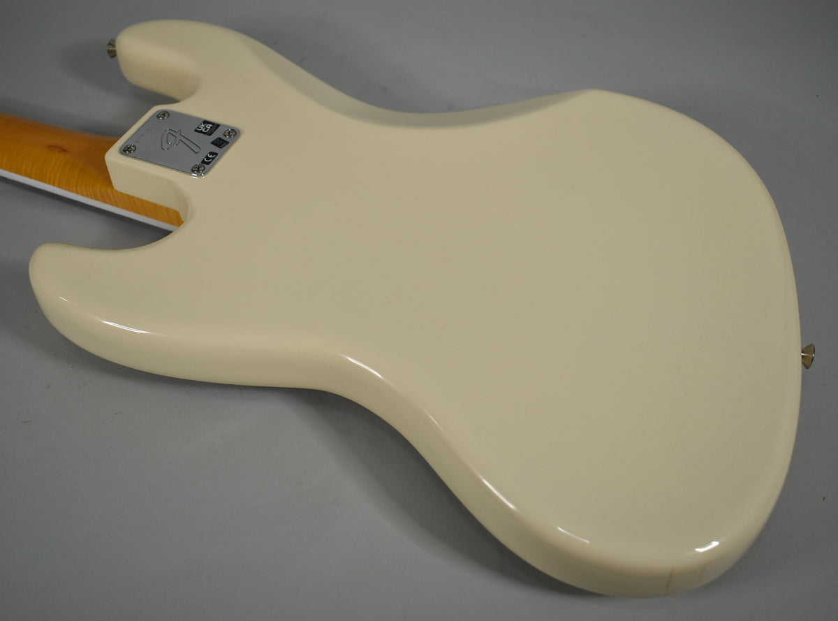 The back of an Olympic White bass body with a glossy finish, showing the neck plate and a small crack near the bottom strap button.