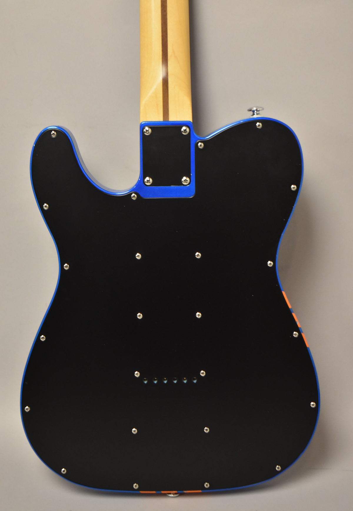 The guitar's back is matte black with a blue edge, showing a maple neck, neck plate, and string-through-body ferrules.