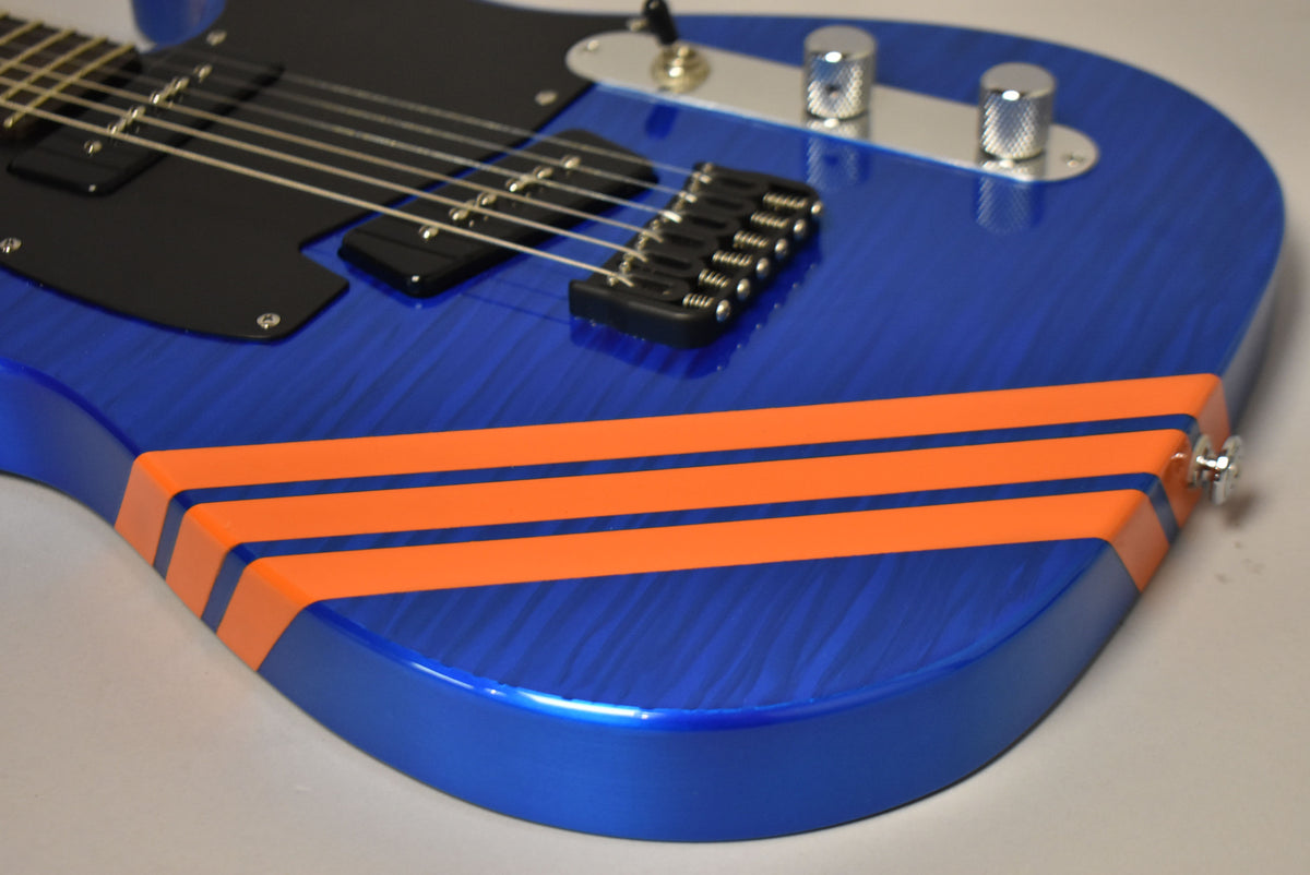 Close-up of the lower bout of a blue flame maple guitar with three orange racing stripes, black P-90 pickups, and chrome hardware.