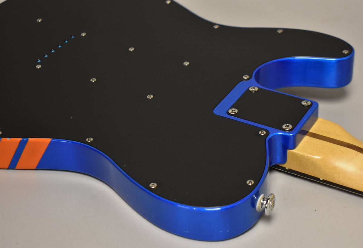 The guitar's blue body with orange stripes is seen from the back, showing a black pickguard, neck plate, and string-through-body ferrules.