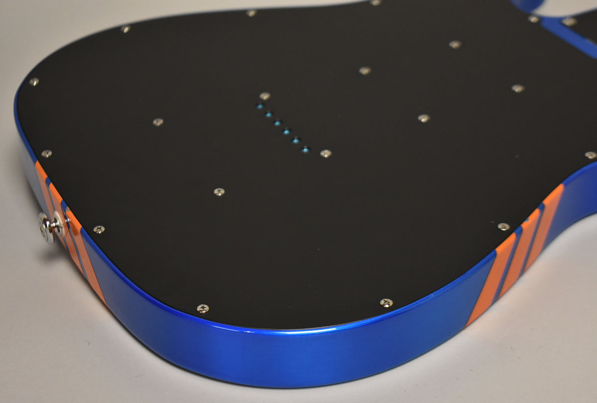The guitar's back shows a black control cavity cover with many screws, a blue body, and orange racing stripes on the side.