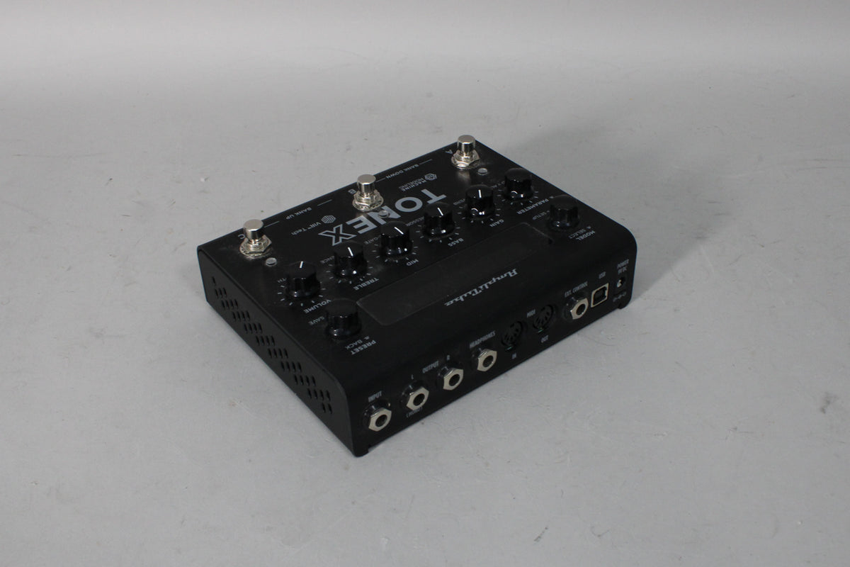 Black multi-effects pedal with four footswitches, eight control knobs, and multiple input/output jacks visible from a top-down angle.