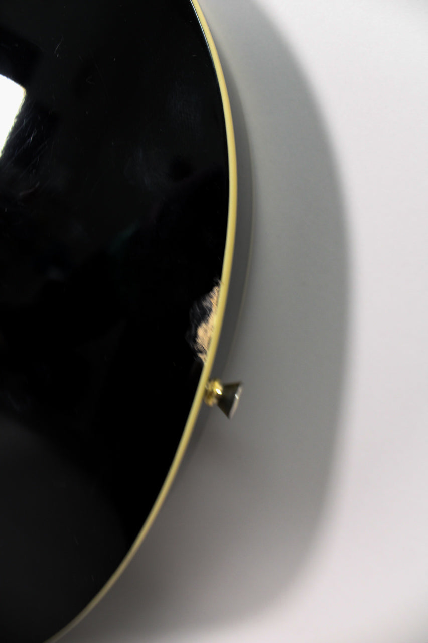 Close-up of the guitar's lower bout, showing a large chip in the black gloss finish exposing light wood, near a gold strap button.