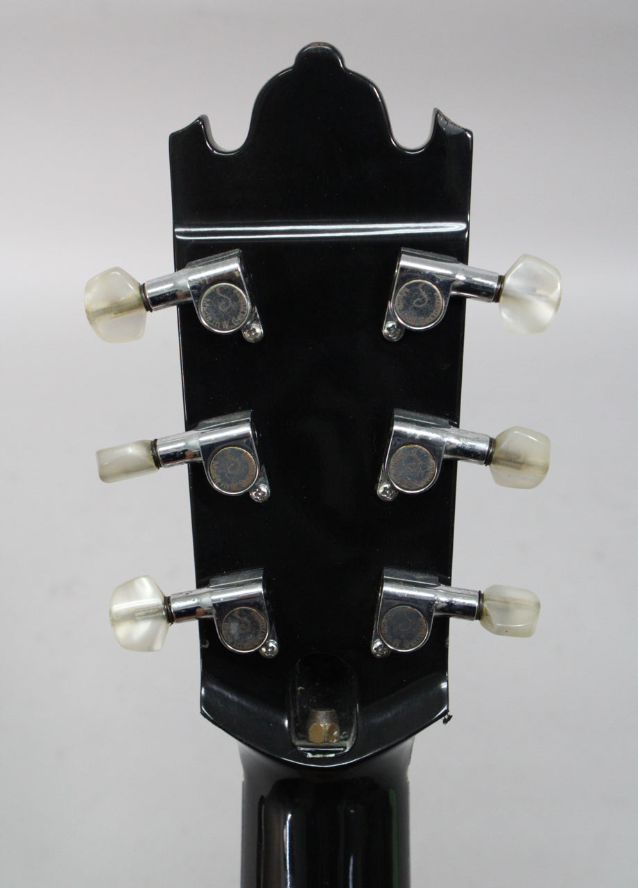 Rear view of the black gloss headstock with six chrome tuners, three per side, with aged translucent plastic buttons.
