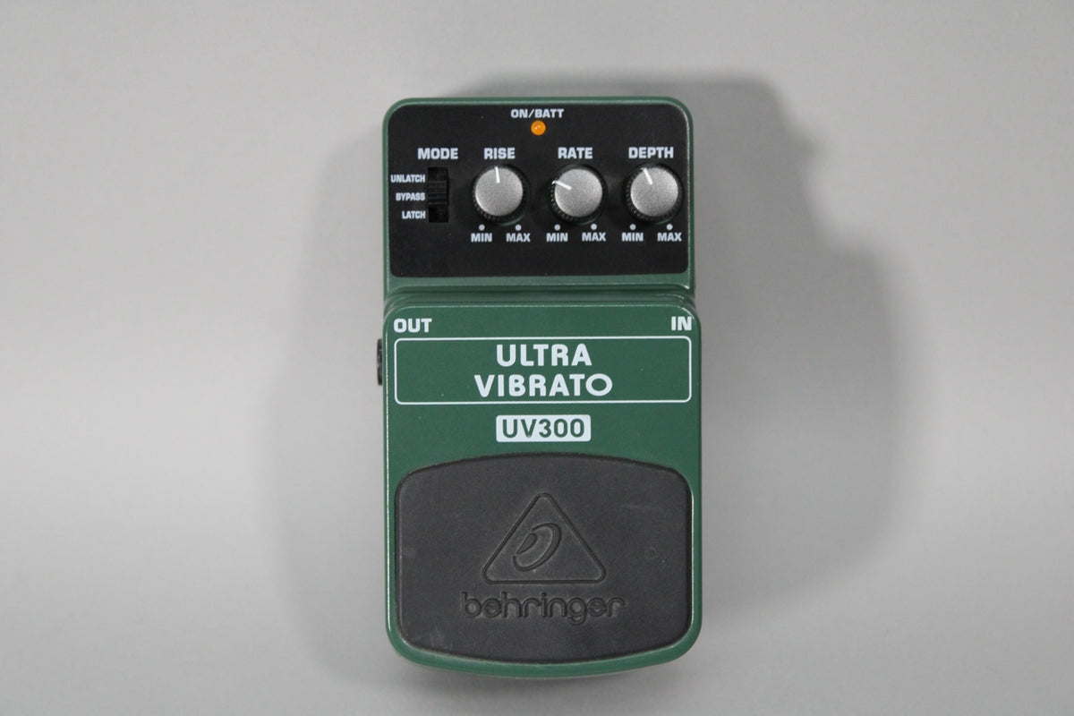 A dark green guitar pedal with a black footpad, three silver knobs, a black mode switch, and an orange indicator light.