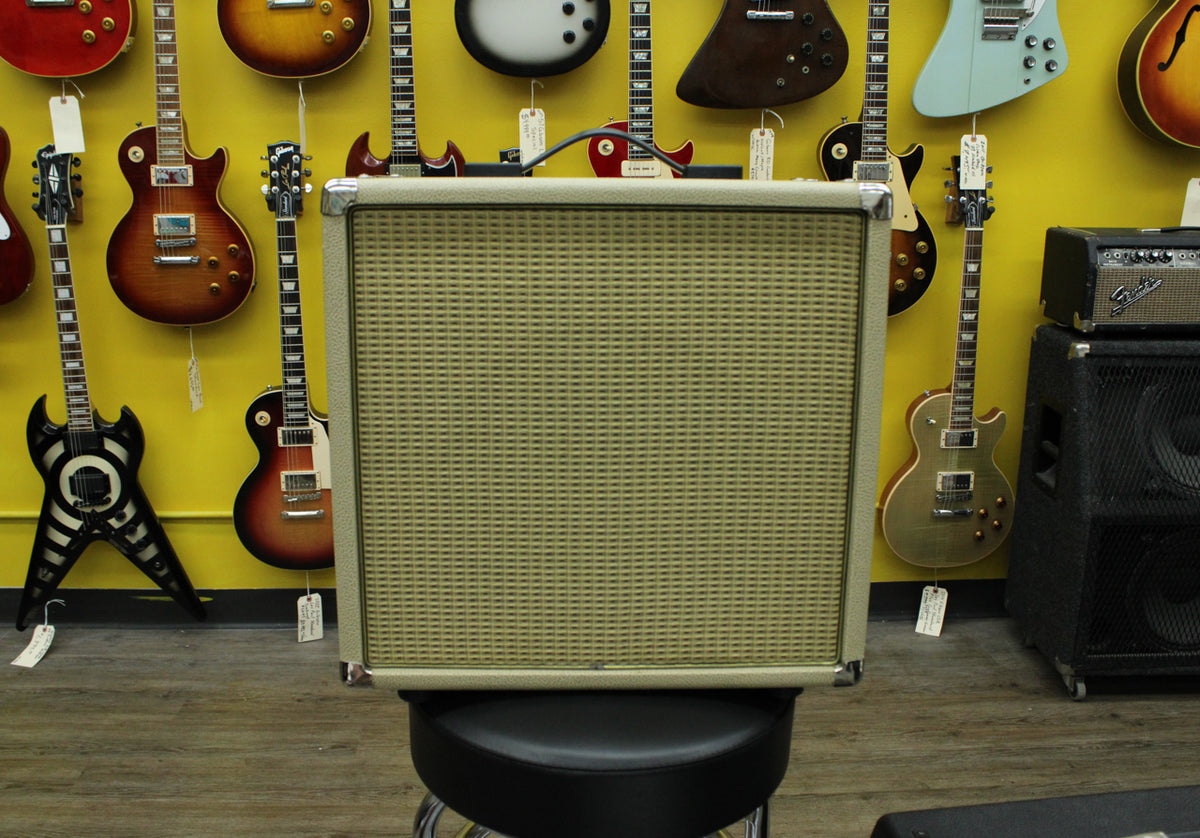 Front view of a blonde extension cab with a light tan woven grille, chrome corner protectors, and a black top handle.