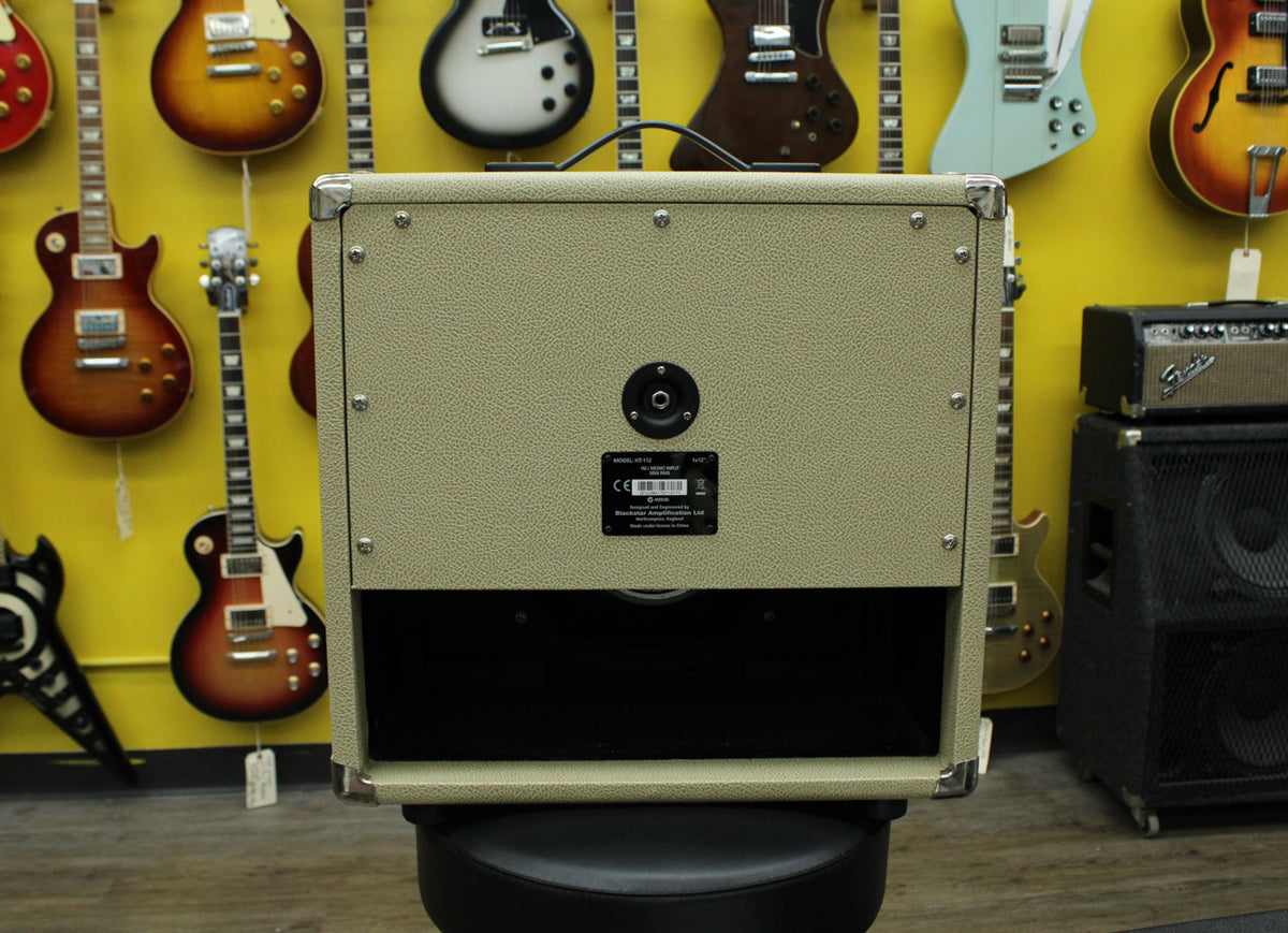 The blonde extension cab is seen from the rear, showing the speaker input, product label, and open-back design.