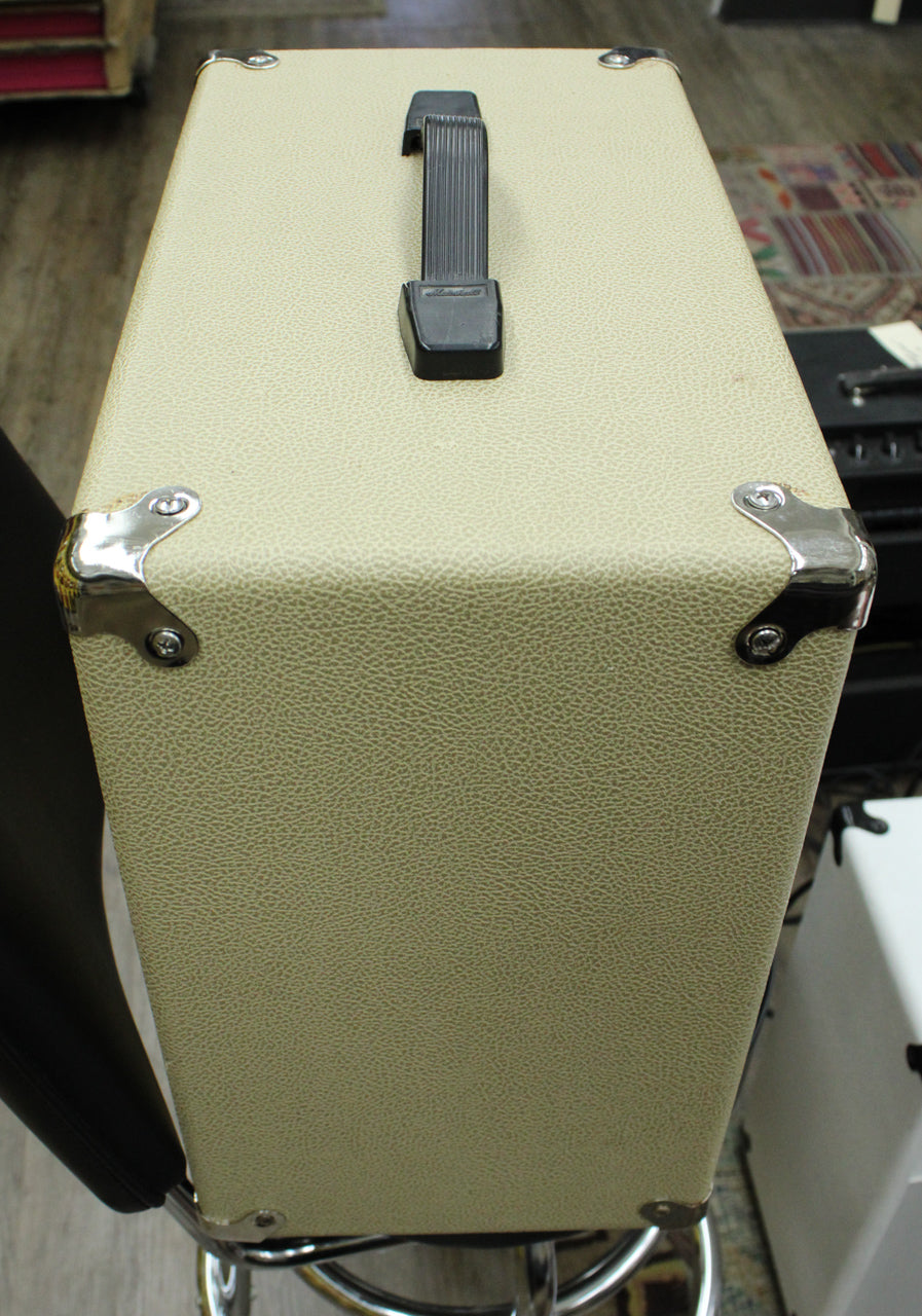The blonde extension cab is viewed from above, showing the textured cream tolex, black plastic handle, and chrome corner protectors.