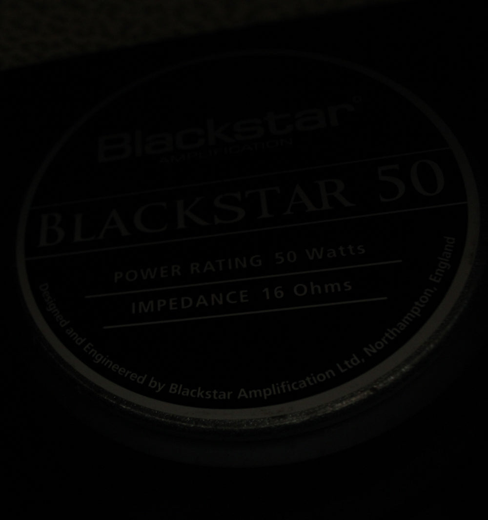 Close-up of the speaker's dark gray label, showing "POWER RATING 50 Watts" and "IMPEDANCE 16 Ohms" in light gray text.