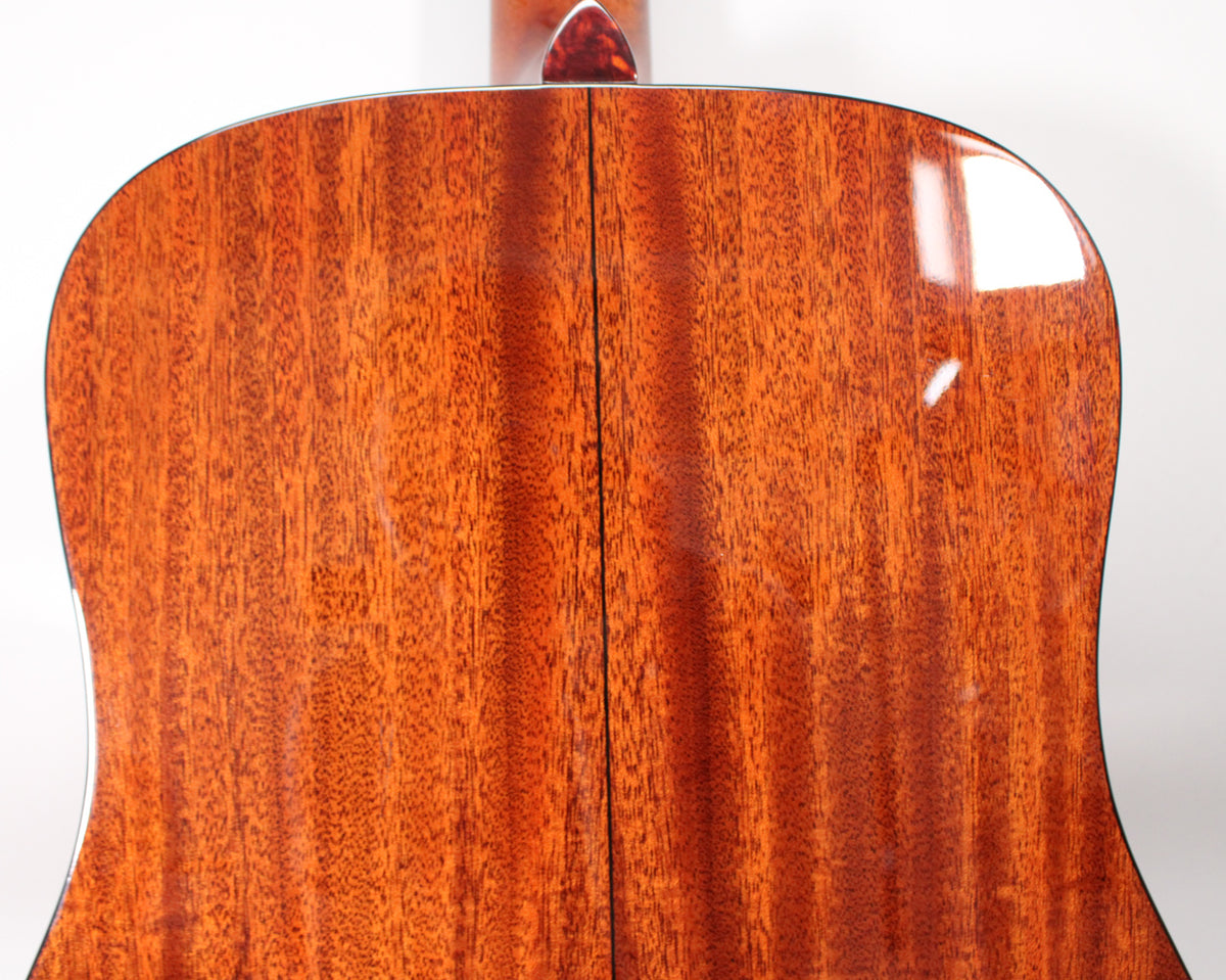 The back of the dreadnought guitar shows a glossy, reddish-brown mahogany finish with a visible two-piece seam down the center.