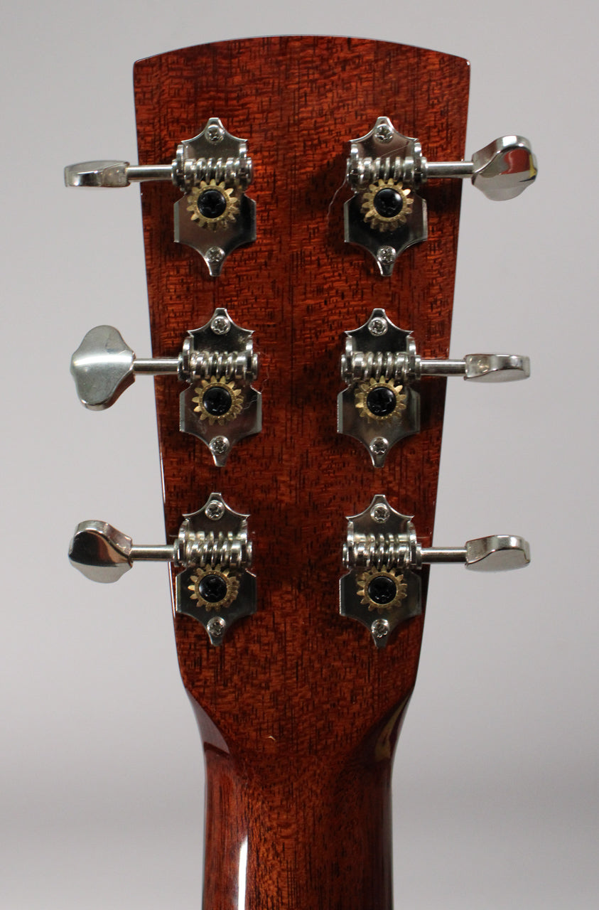 Rear view of the mahogany headstock and neck, showing six open-gear tuners with chrome buttons and gold gears.