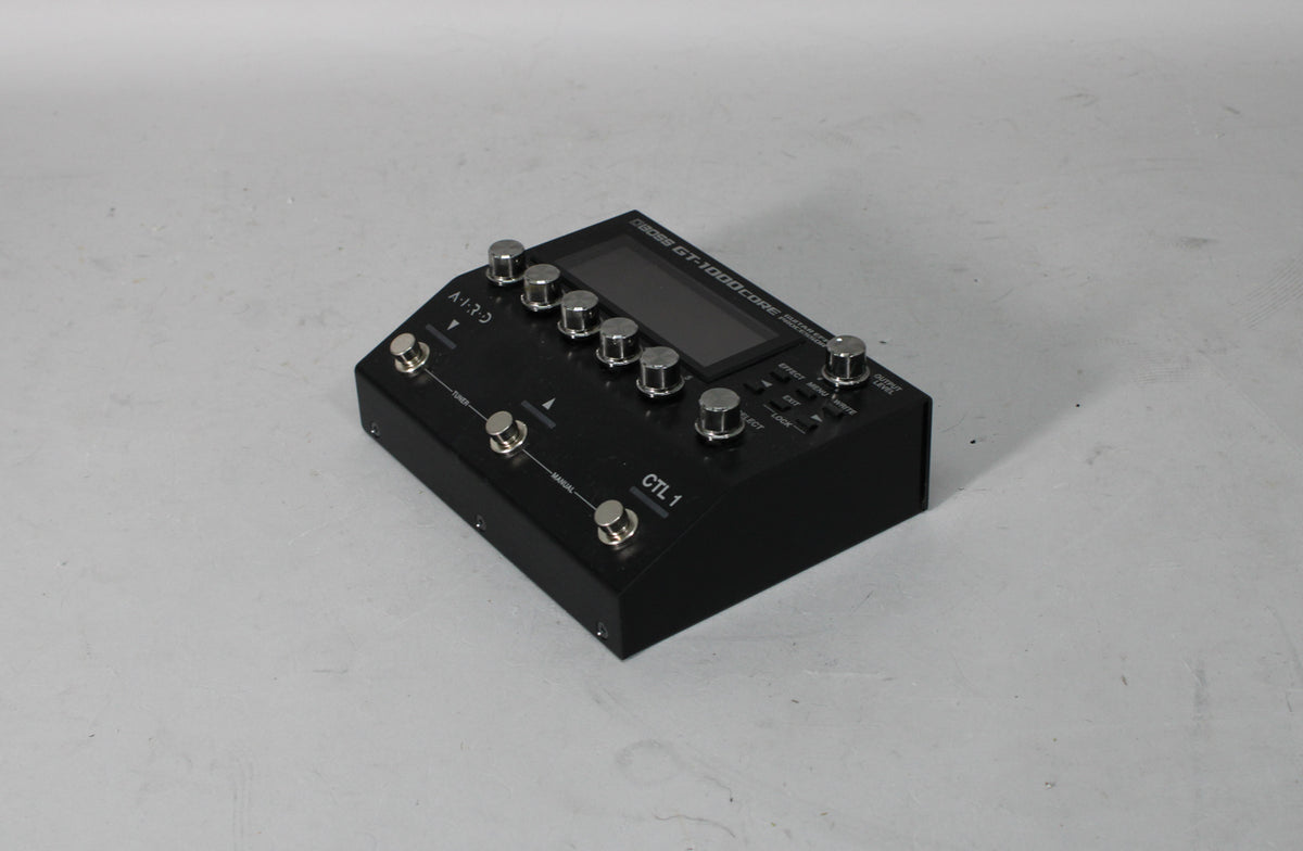 A black multi-effect processor with a screen, eight silver knobs, and five silver footswitches, viewed from the front-right.