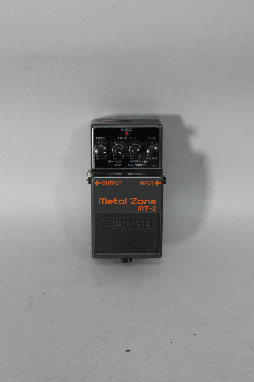 A dark gray metal effect pedal, viewed from above, with four black control knobs and a red "CHECK" indicator light.